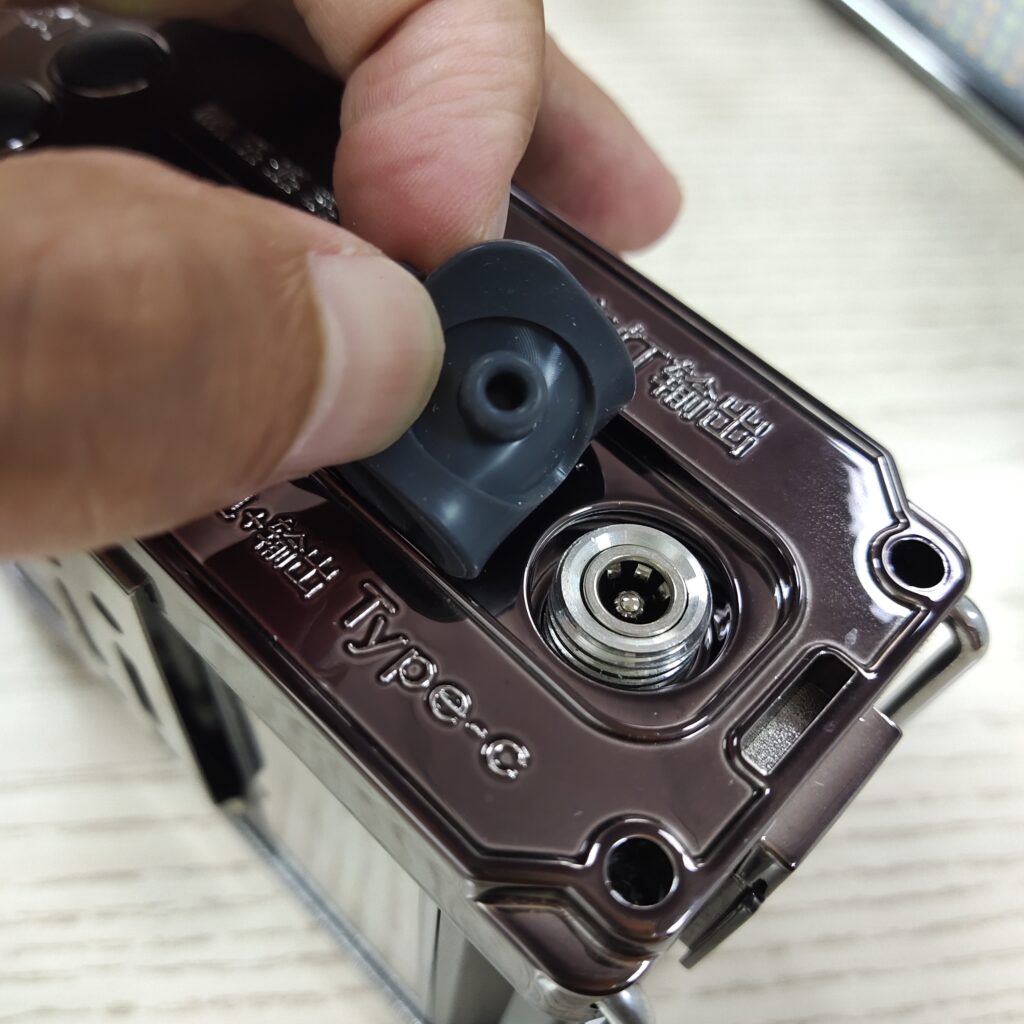 Close up of the DC quick charge port with rubber weather sealing cap on the split headlamp battery housing